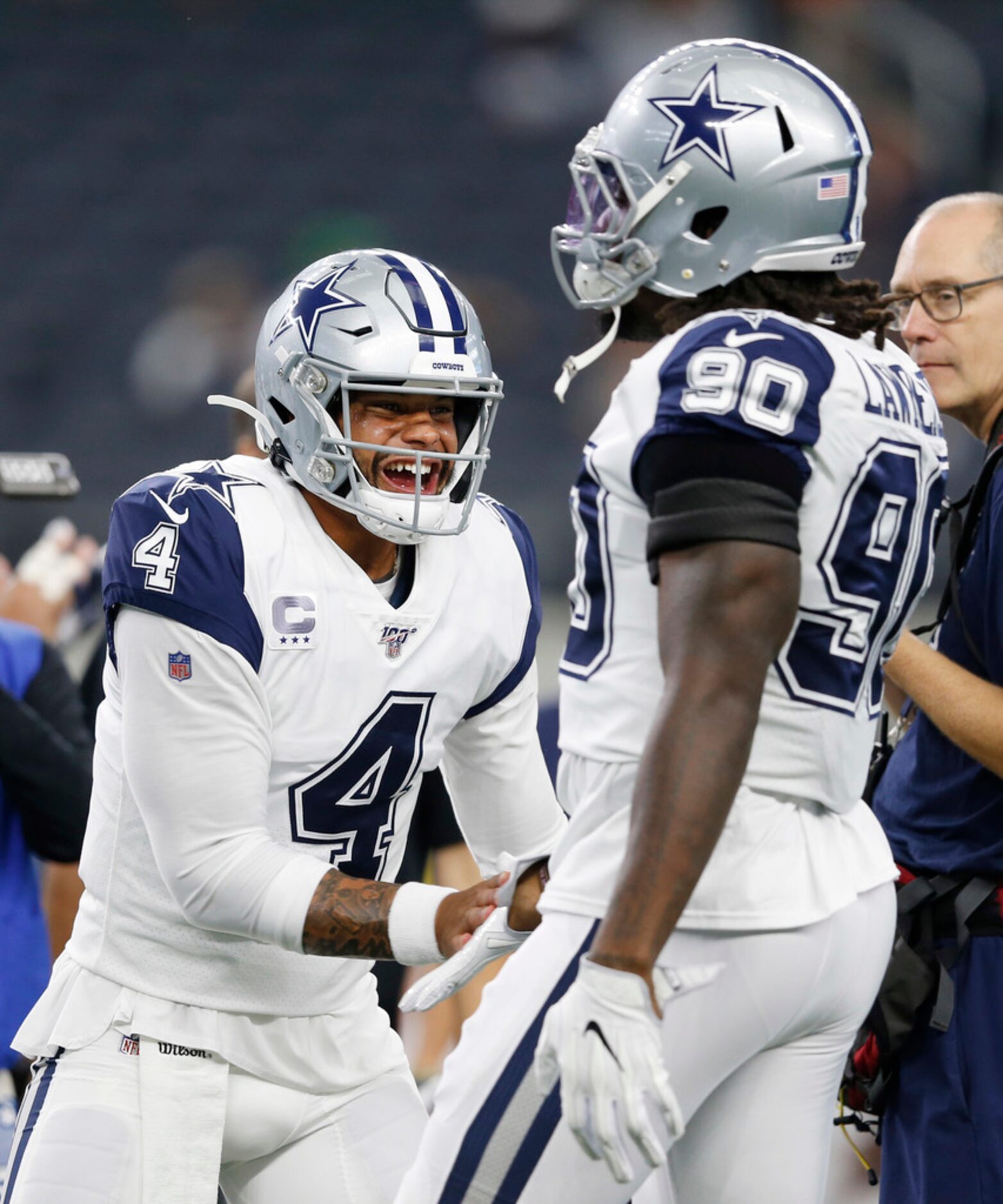 Dallas Cowboys quarterback Dak Prescott (4) greets Dallas Cowboys defensive end Demarcus...