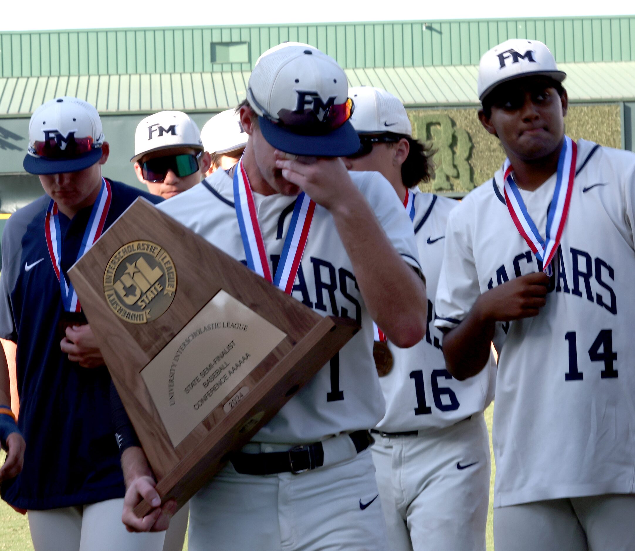 Flower Mound outfielder Garrett Wallace (1) holds the Class 6A semifinalist trophy presented...