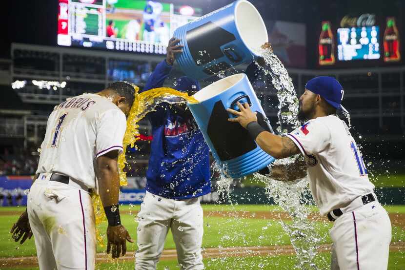 Texas Rangers second baseman Rougned Odor (12) dunks shortstop Elvis Andrus with Powerade as...