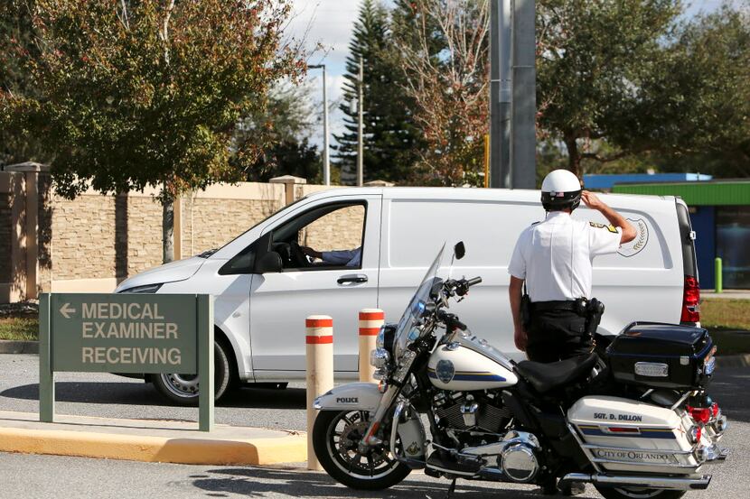 Law enforcement officers salute as the body of the Orange County deputy that died in the...