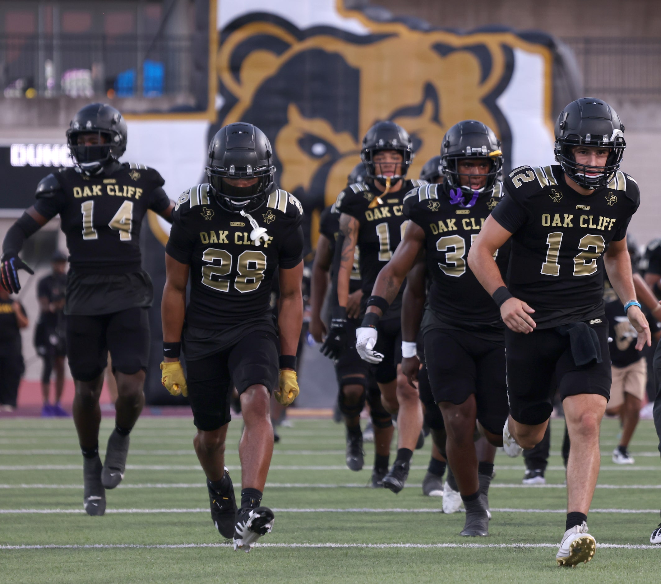 South Oak Cliff quarterback Carter Kopecky (12), right, leads teammates out of the team...