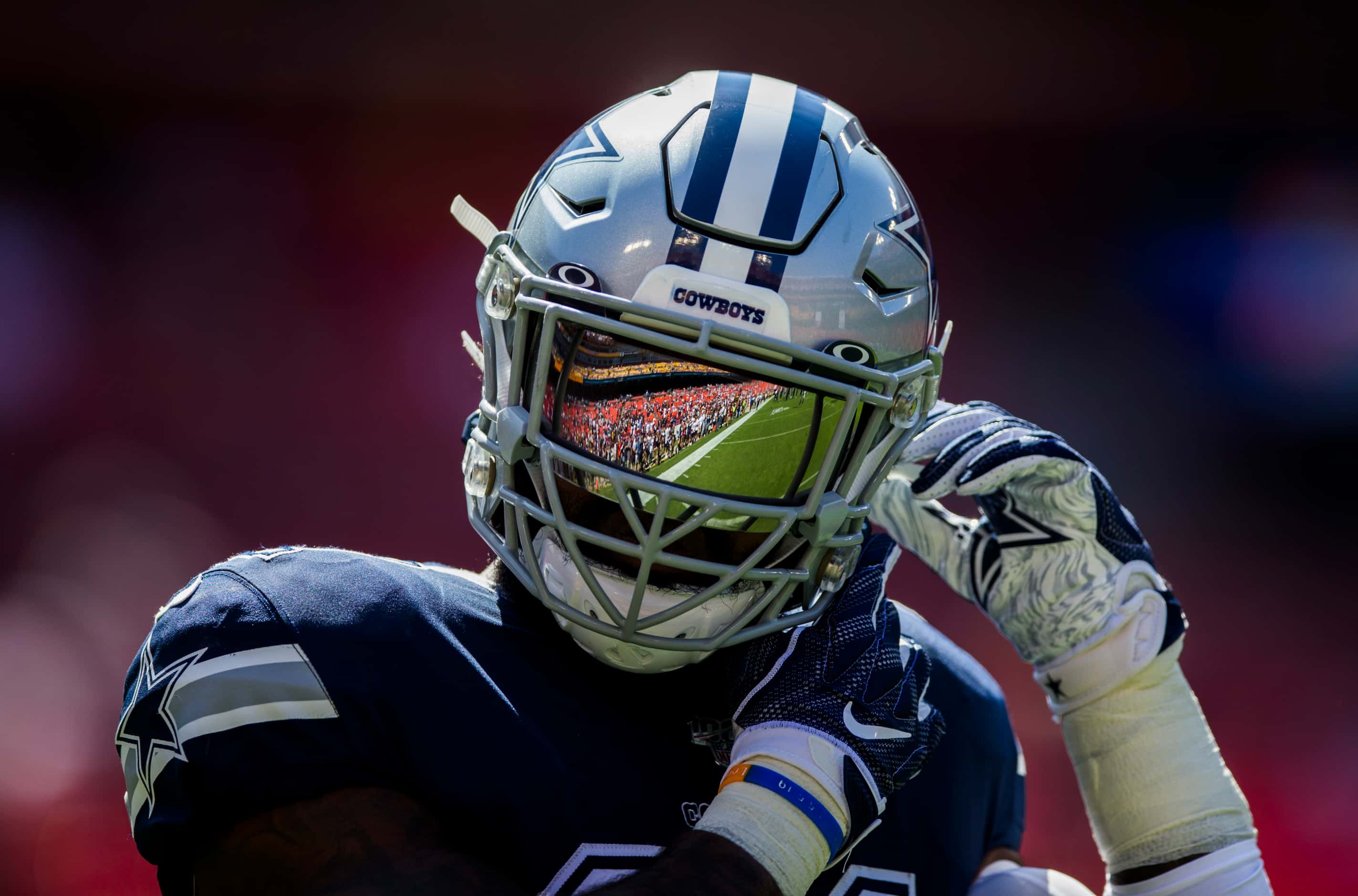 Dallas Cowboys running back Ezekiel Elliott (21) has the field reflected in his helmet as he...