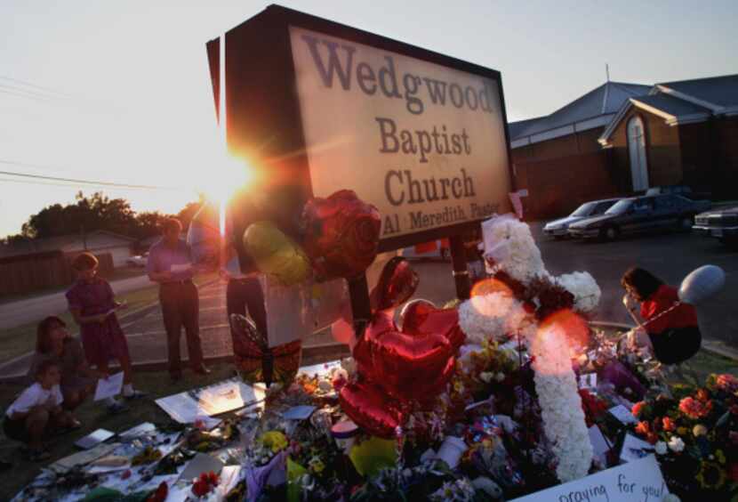 People visit a makeshift memorial on Sept. 10, 2000, outside Wedgwood Baptist Church in Fort...