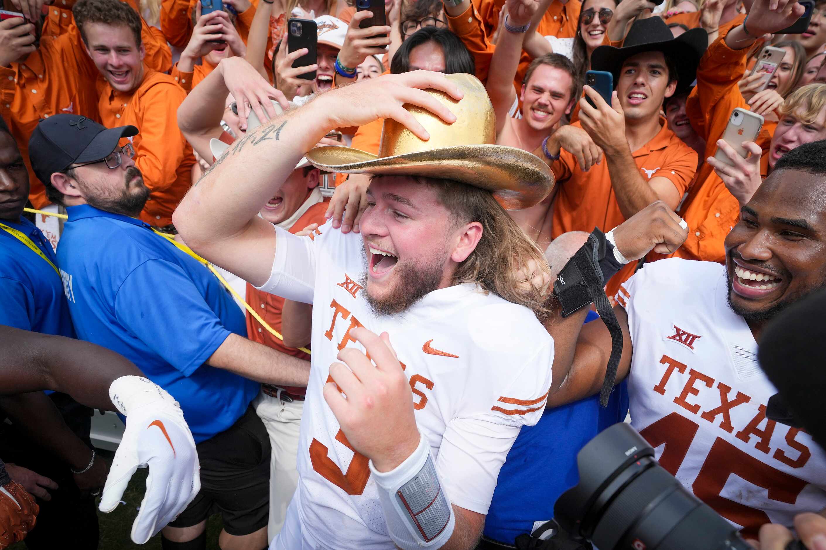 Texas quarterback Quinn Ewers dons the Golden Hat trophy as he celebrates with fans after a...