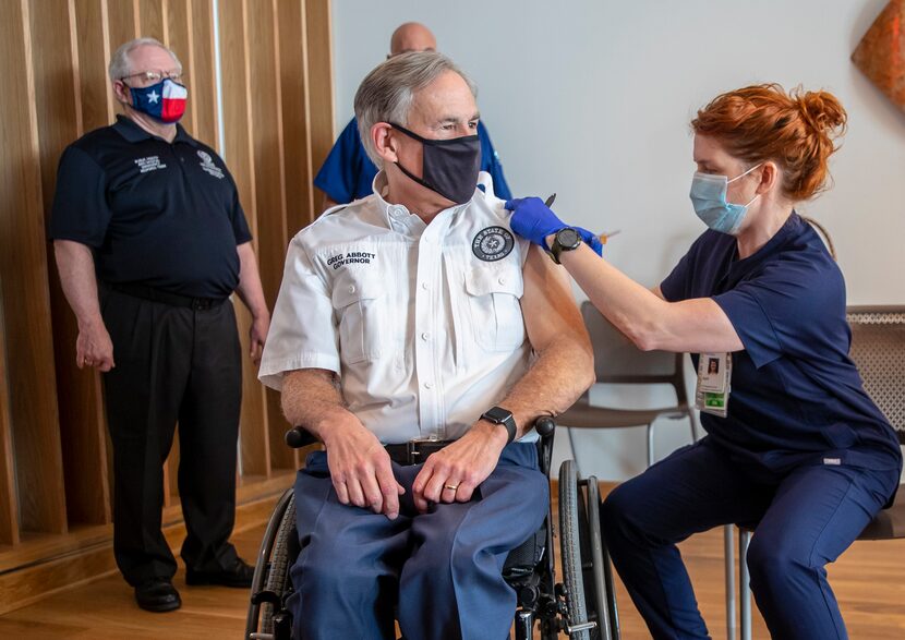 Registered nurse April Burge gave Texas Gov. Greg Abbott a COVID-19 vaccine shot on Dec. 22,...