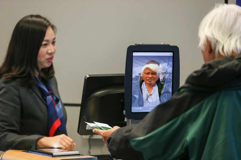 Gate agent Erica Shin assists as passengers board an American Airlines flight to Tokyo...