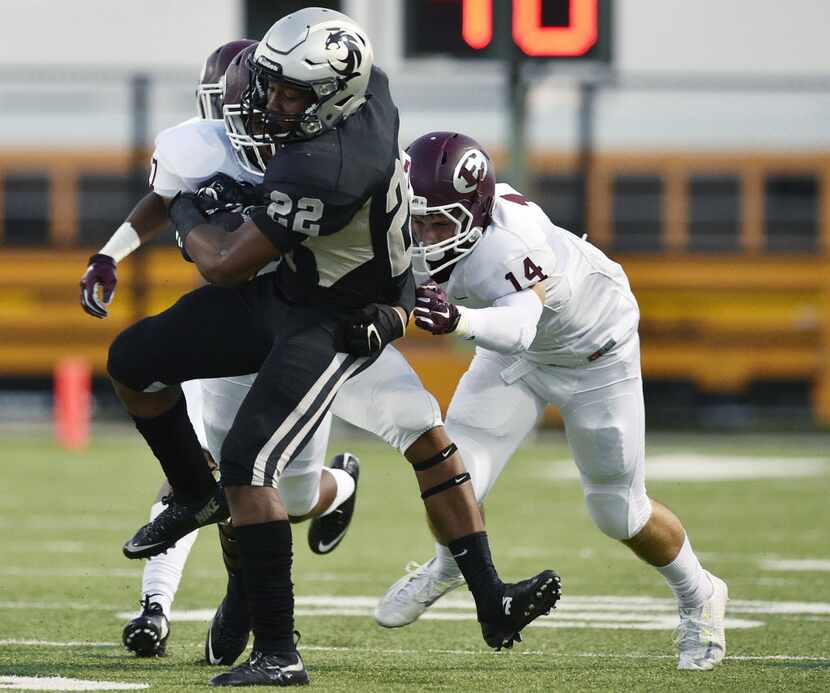 Guyer freshman running back Noah Cain (22) tries to keep on his feet during a tackle by...