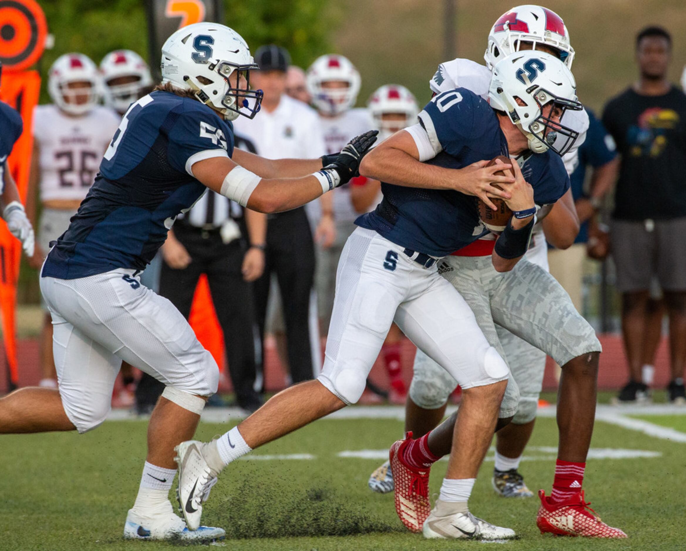 All Saints' Episcopal quarterback Matthew Epperson (10) makes a run but is sacked by Bishop...