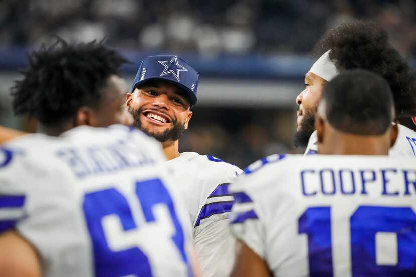 Dallas Cowboys quarterback Dak Prescott laughs on the bench with offensive tackle La'el...