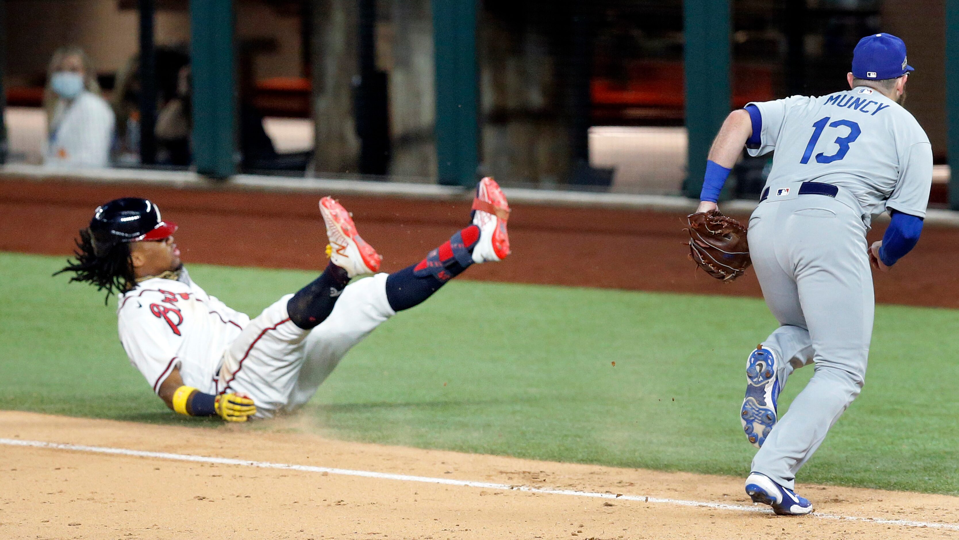 Los Angeles Dodgers first baseman Max Muncy (13) chases down the throw as Atlanta Braves...