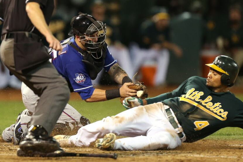 Oakland's Coco Crisp scores on a sacrifice fly in the fifth inning as Rangers catcher Mike...