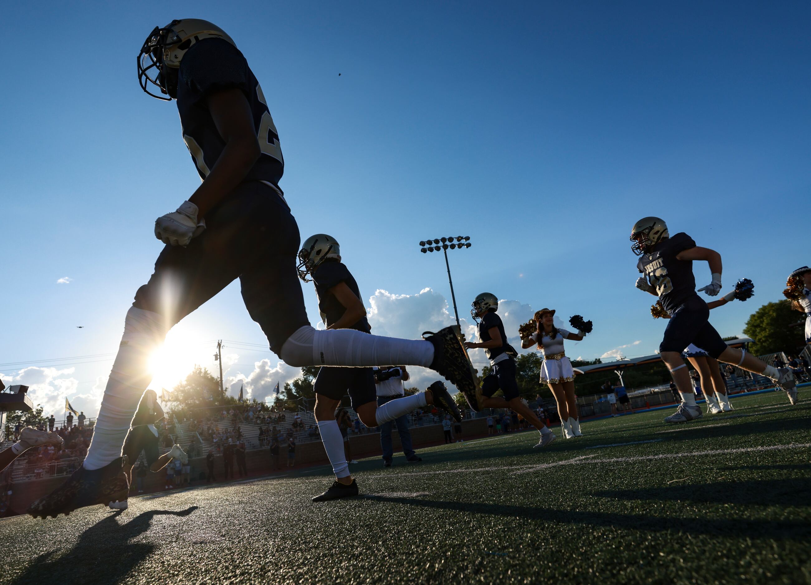 Jesuit High School players run onto the field before the football game between Jesuit High...