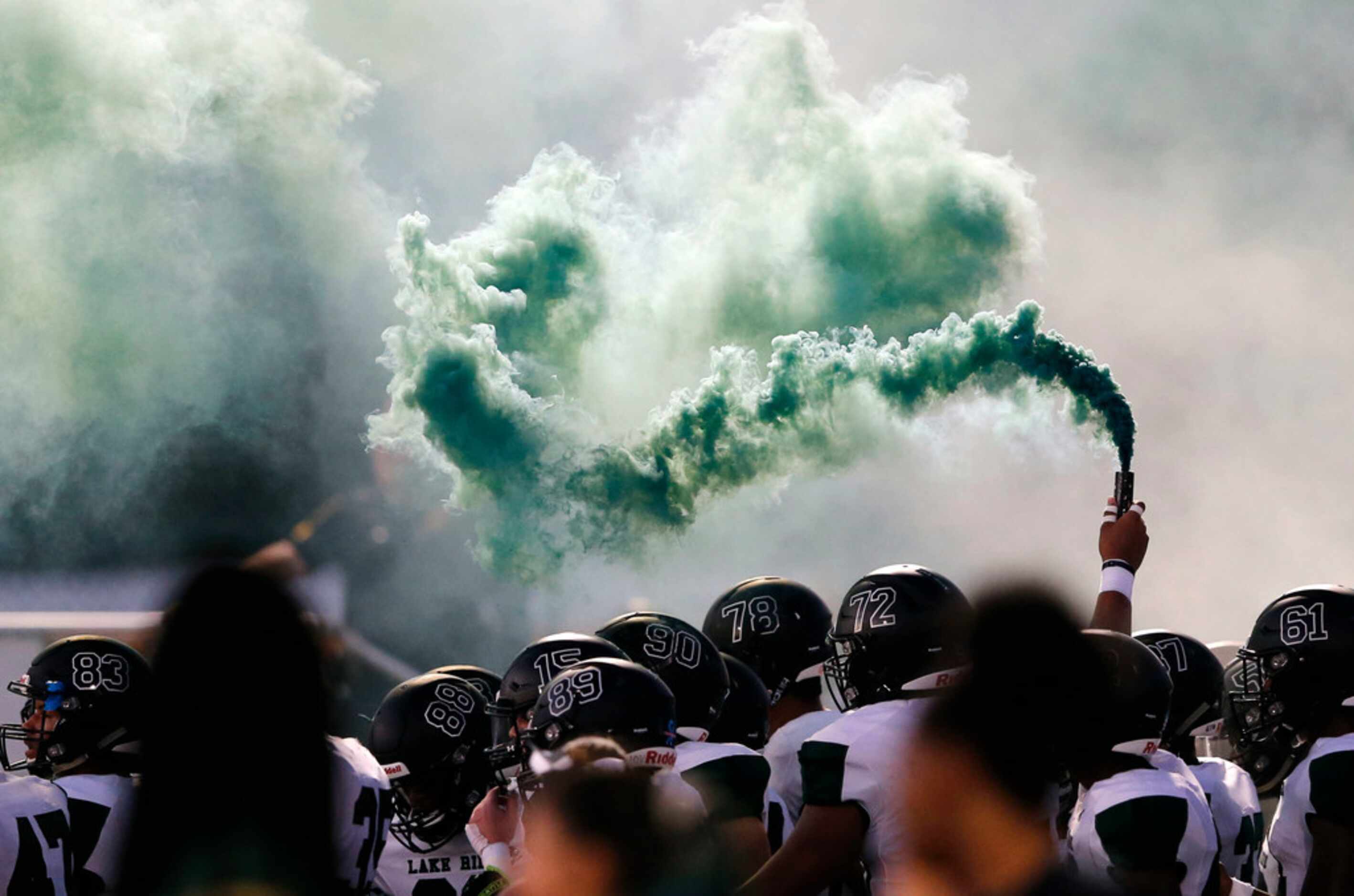 Mansfield Lake Ridge lets out green smoke before taking the field in a game against DeSoto...