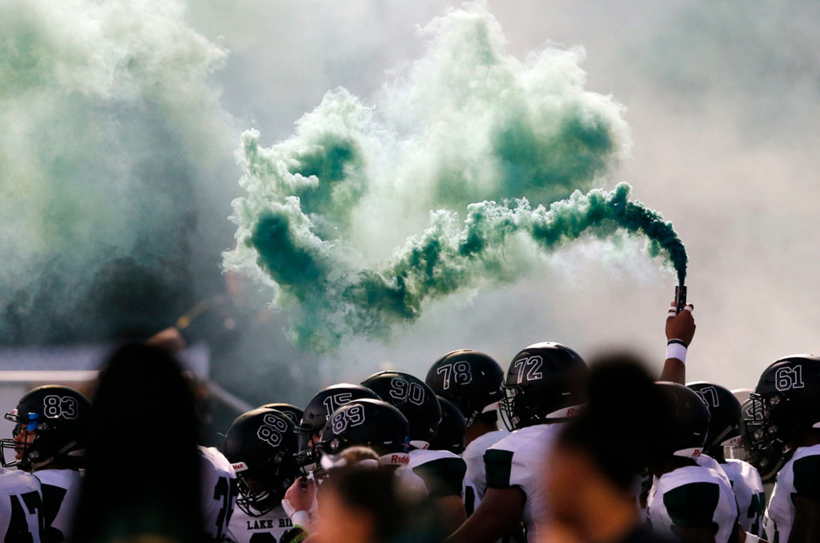 Mansfield Lake Ridge lets out green smoke before taking the field in a game against DeSoto...