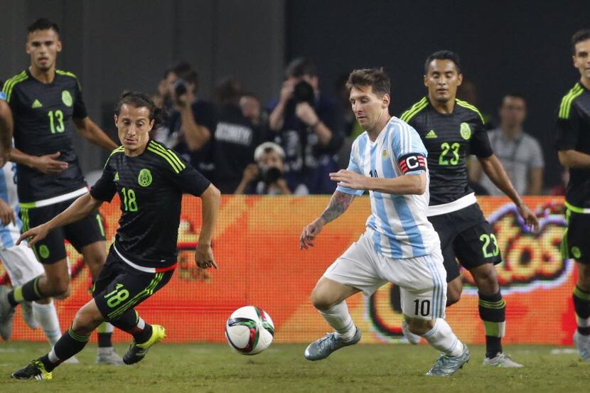 Argentina's Lionel Messi (10) is surrounded by the Mexico defense during the second half...
