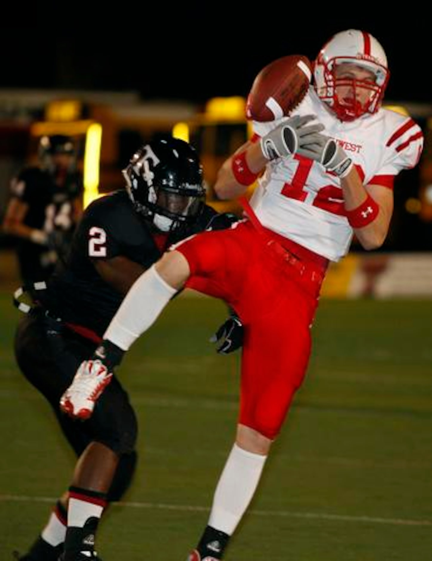 Justin Northwest junior Taylor Barnhill (12) makes a catch after bobbling it and being hit...