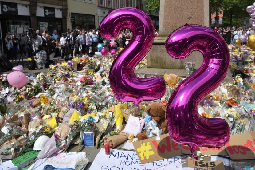 Balloons forming the number 22 are pictured alongside flowers and messages of support in St...