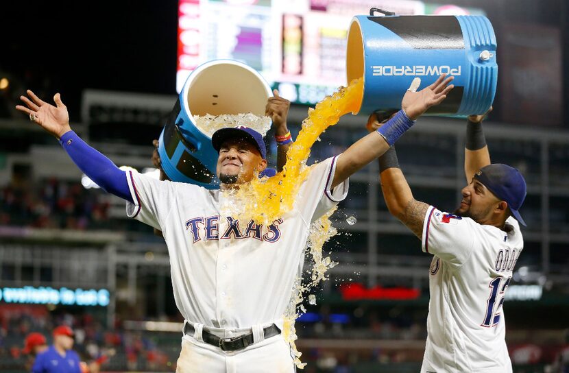 Texas Rangers left fielder Carlos Gomez (14) gets doused by second baseman Rougned Odor (12)...