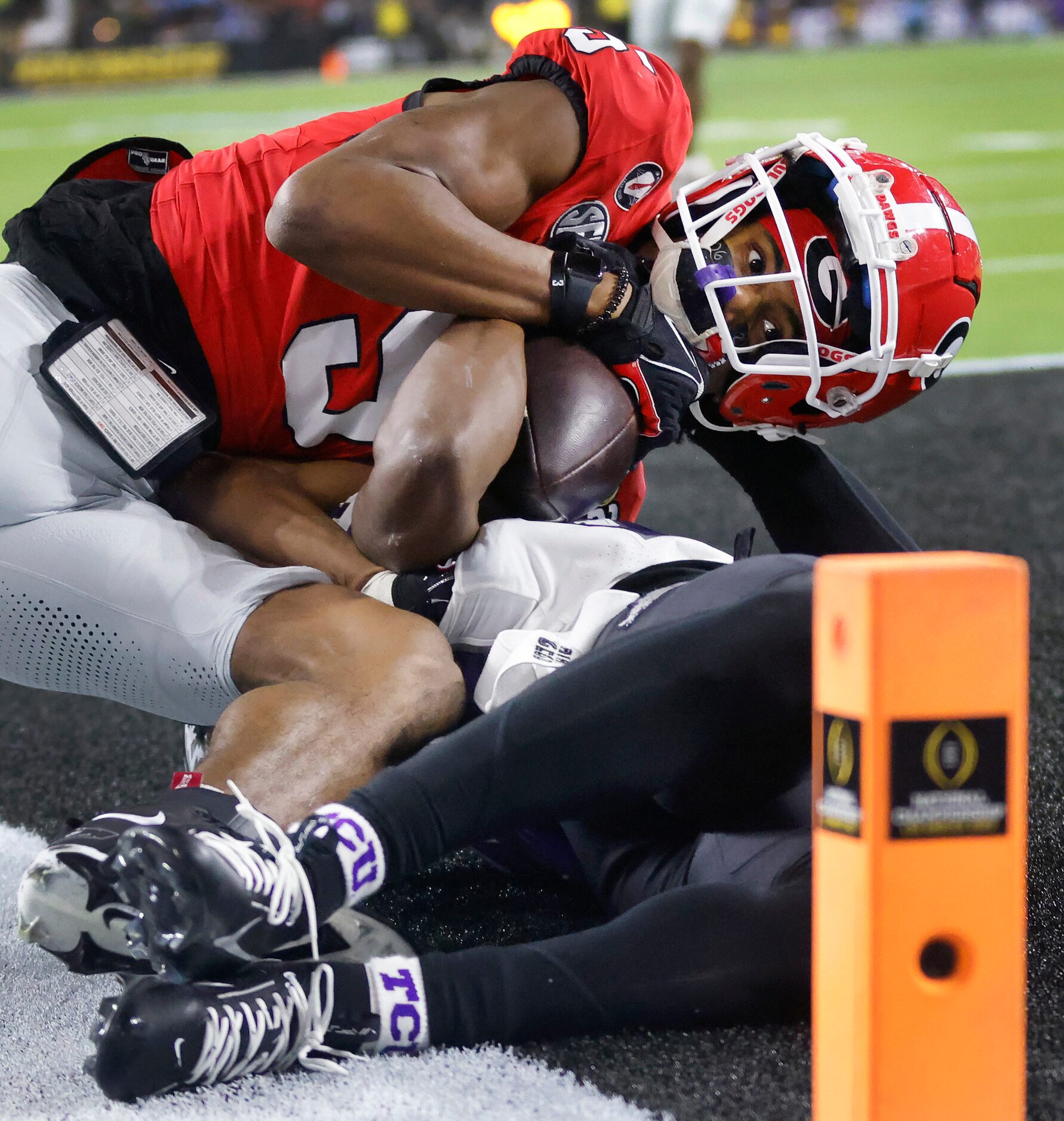 Georgia Bulldogs wide receiver Adonai Mitchell (5) wrestles with TCU Horned Frogs cornerback...