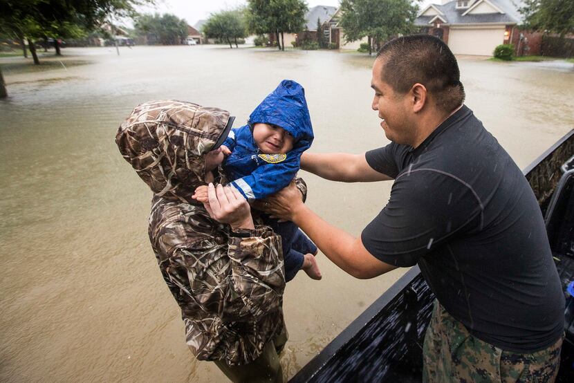 Wilfredo Linares reaches out for his baby, Mason, as they are evacuated from Grand Mission...