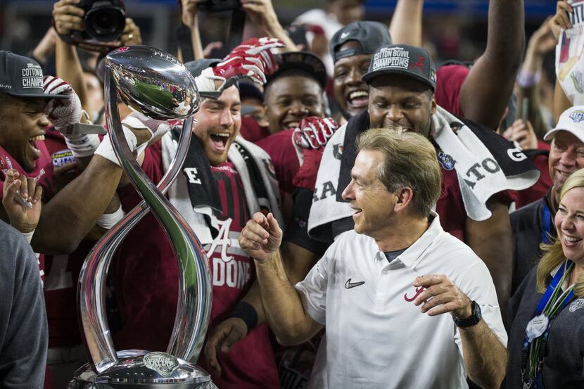 Alabama head coach Nick Saban is encouraged to dance by his players as they celebrate after...