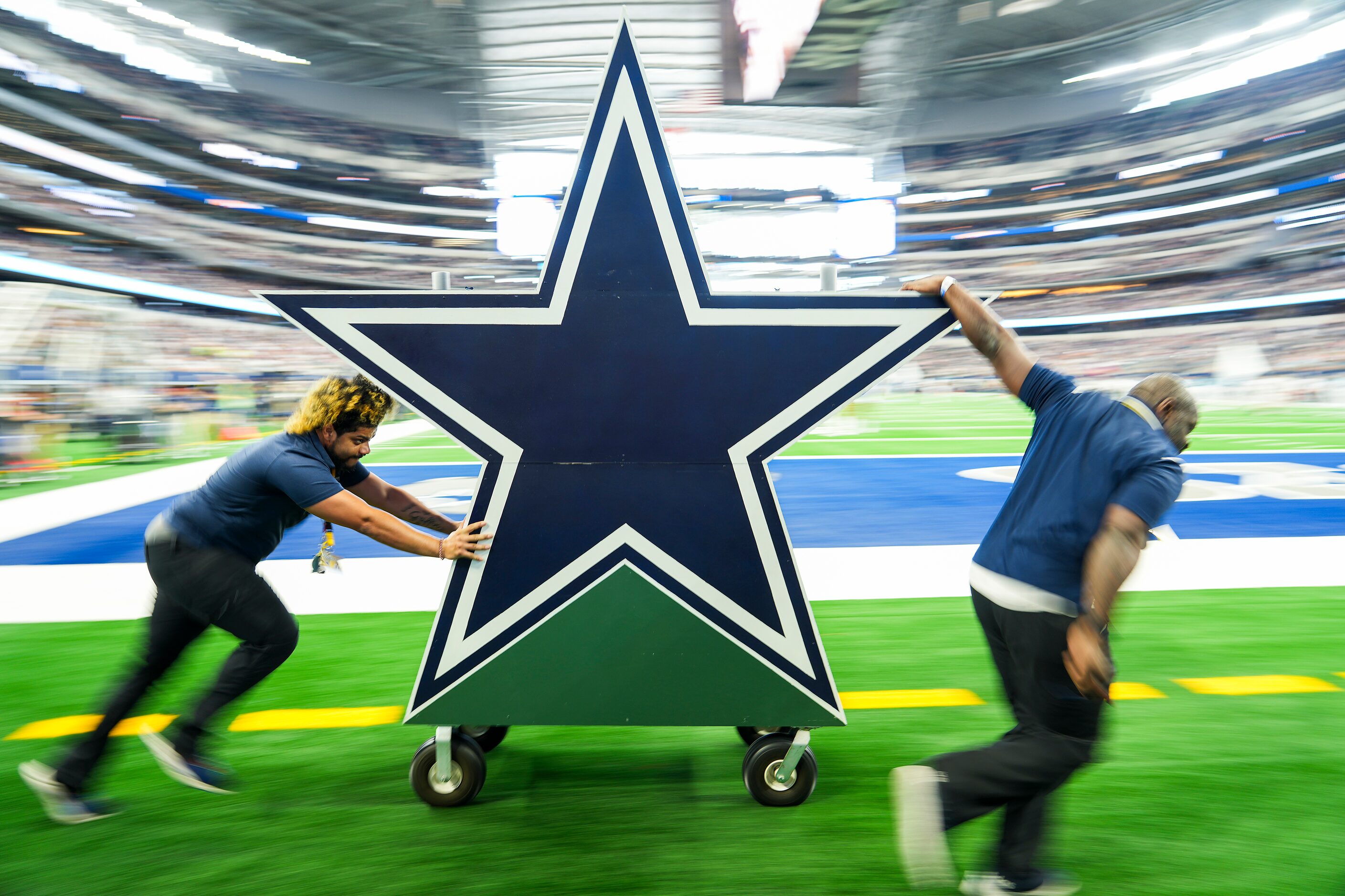 Workers rush a Dallas Cowboys star off the field before an NFL preseason football game...