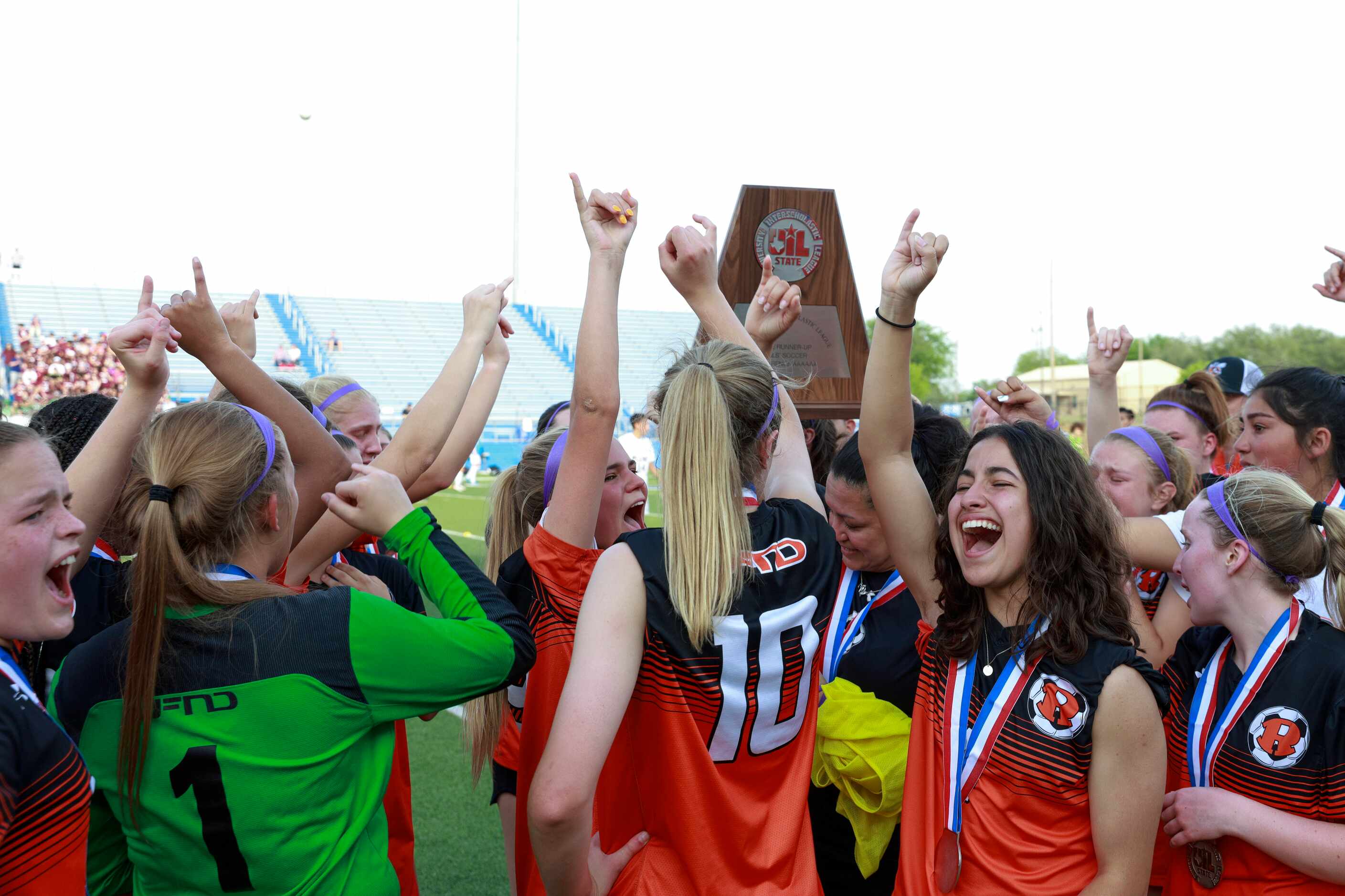 Rockwall players raise the the Class 6A girls soccer state runner-up trophy and chant at...