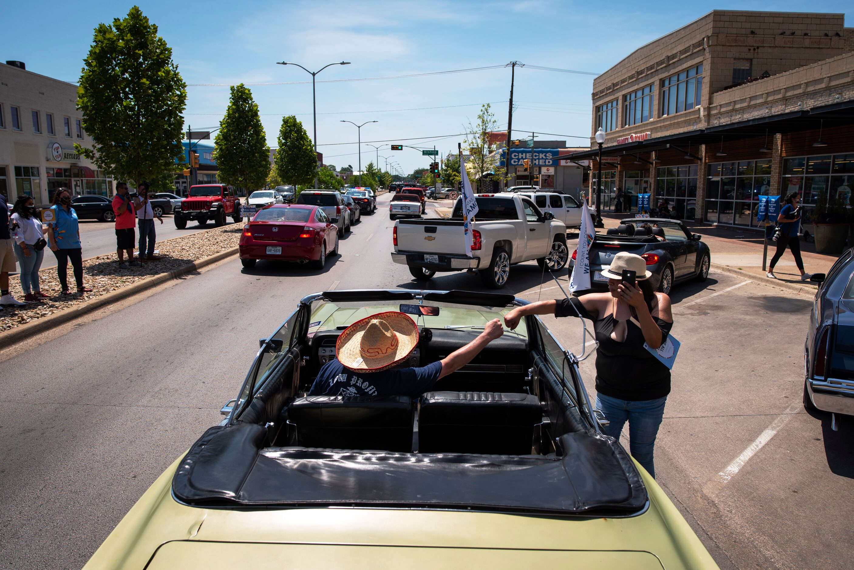 Chris Sierra, left, of Low Profile car club, fist bumps Lucy Bocanegra, right, as she...