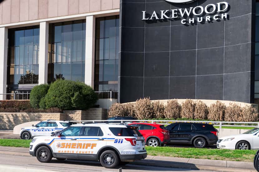 Emergency vehicles line the feeder road outside Lakewood Church during a reported active...