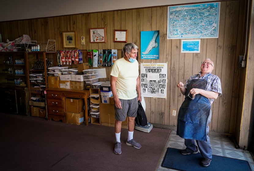 Jimmy Velis (right), owner of Deno’s Shoe Repair on Lovers Lane, laughs with Vic Colon, who...