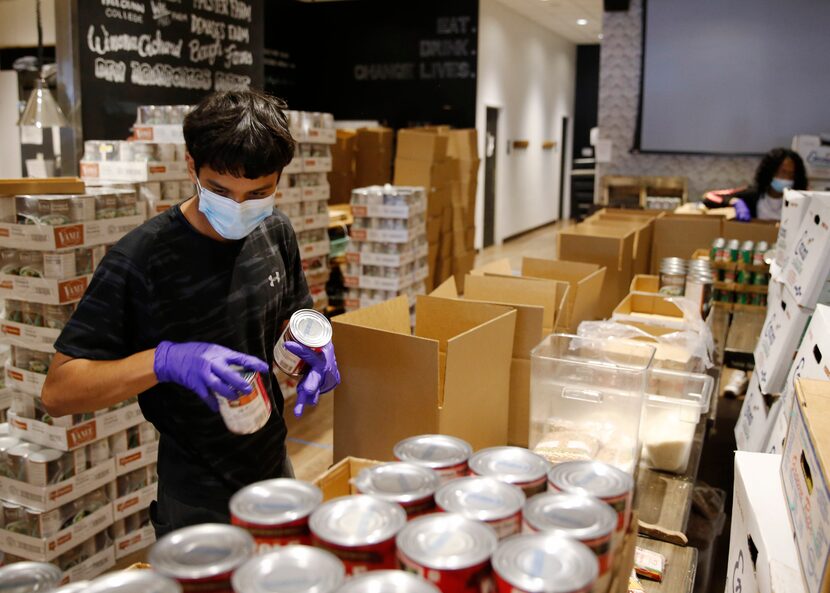 Intern Daniel Casillas worked Wednesday to help put together food kits at Café Momentum....