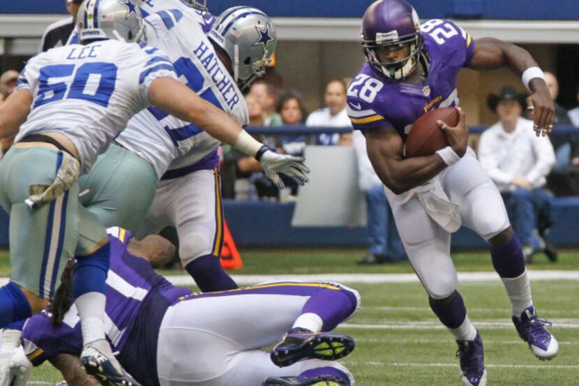 Minnesota Vikings running back Adrian Peterson (28) motors past Dallas Cowboys defensive...