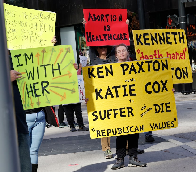 Lynette Sharp of Watauga holds a sign with other supporters during a solidarity march for...