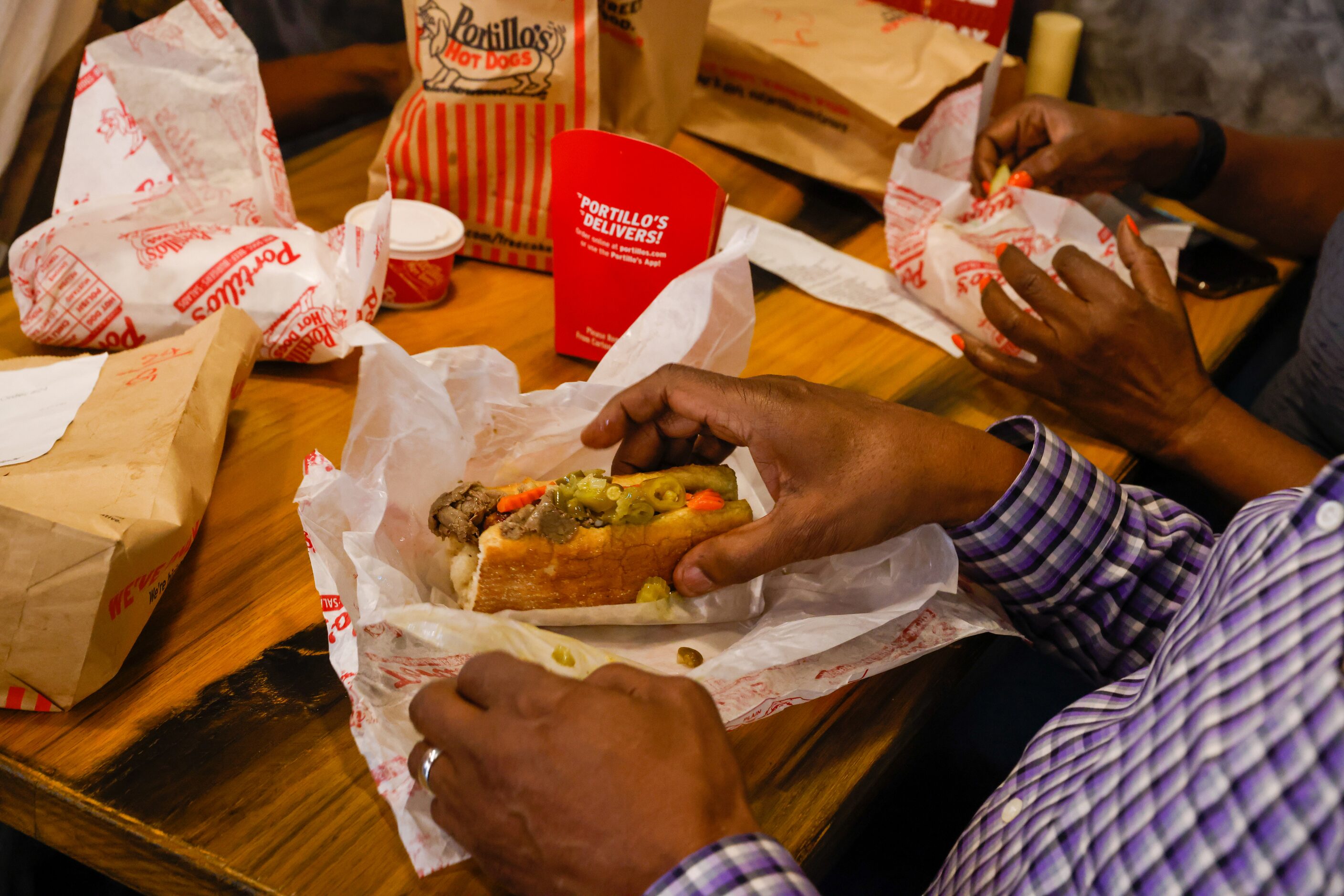 George Peters picks up his Portillo’s Italian Beef & Sausage Combo (front) in The Colony on...