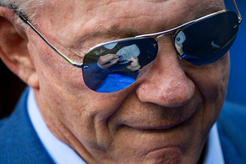 Dallas Cowboys owner Jerry Jones signs autographs for fans before an NFL football game...