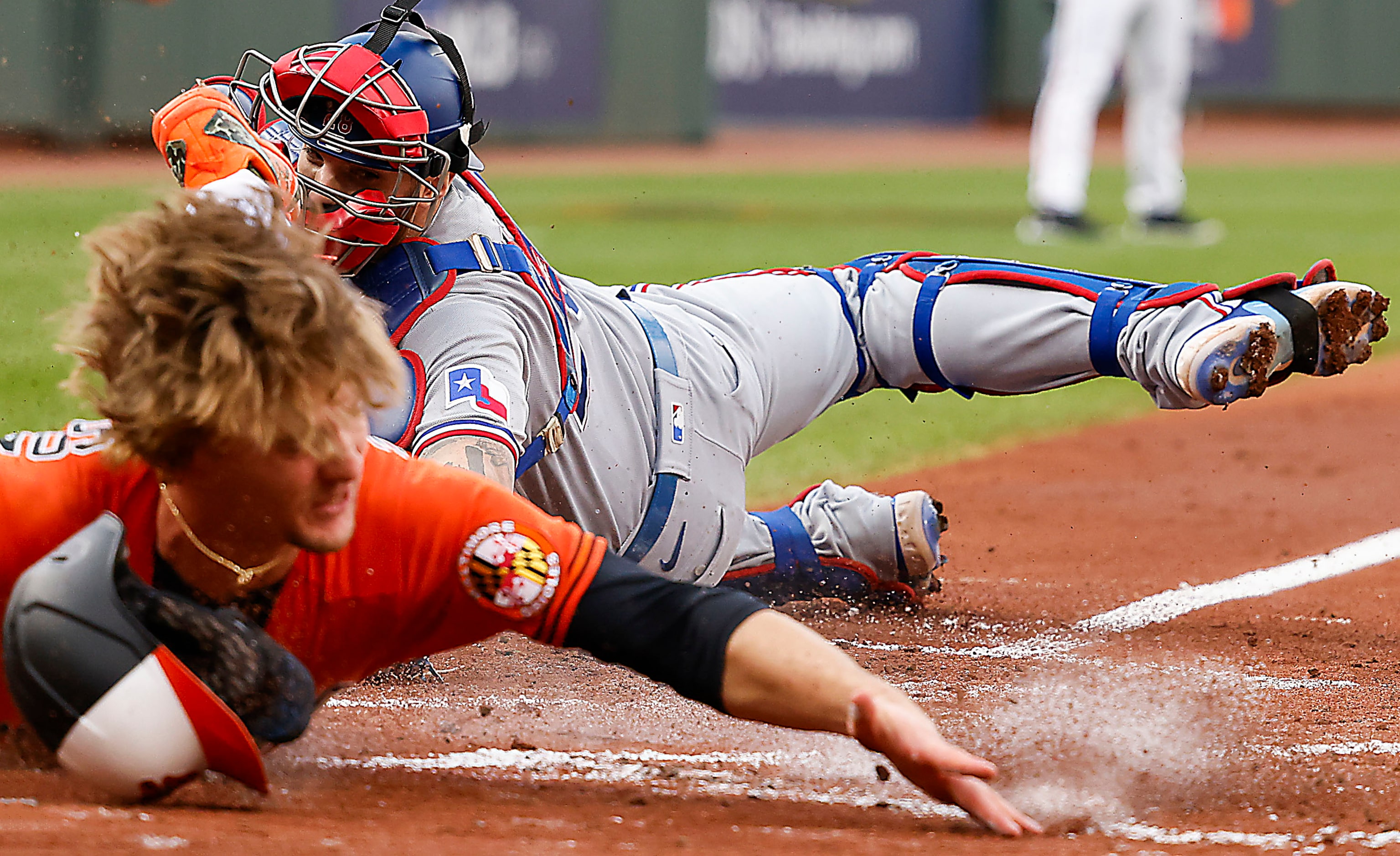 Baltimore Orioles third baseman Gunnar Henderson scores past Texas Rangers catcher Jonah...