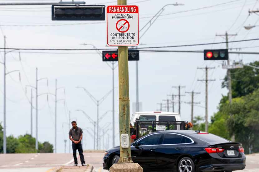 A sign encourages people not to support panhandling in a southern Dallas intersection in...
