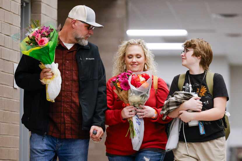 From left, Phillip Hightower, his wife, Amy, and son Max, talk among themselves as they exit...