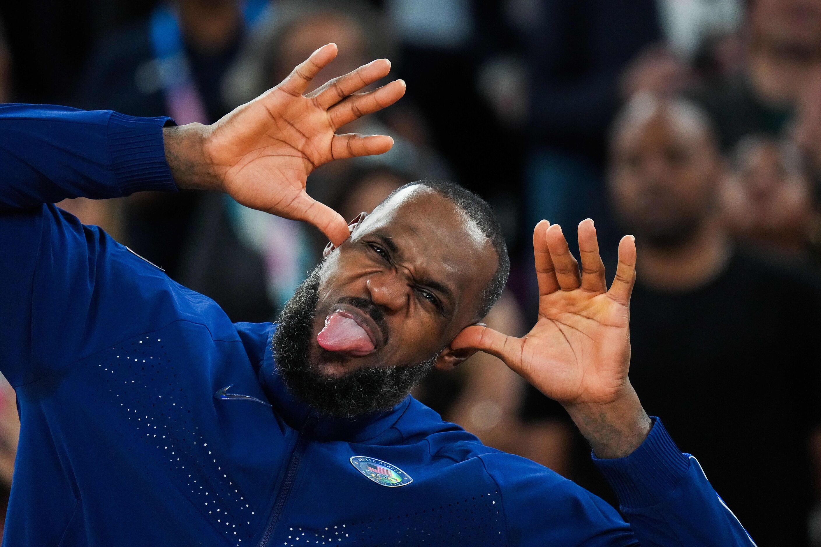 Lebron James of the United States makes face to his family from the medals podium after a...