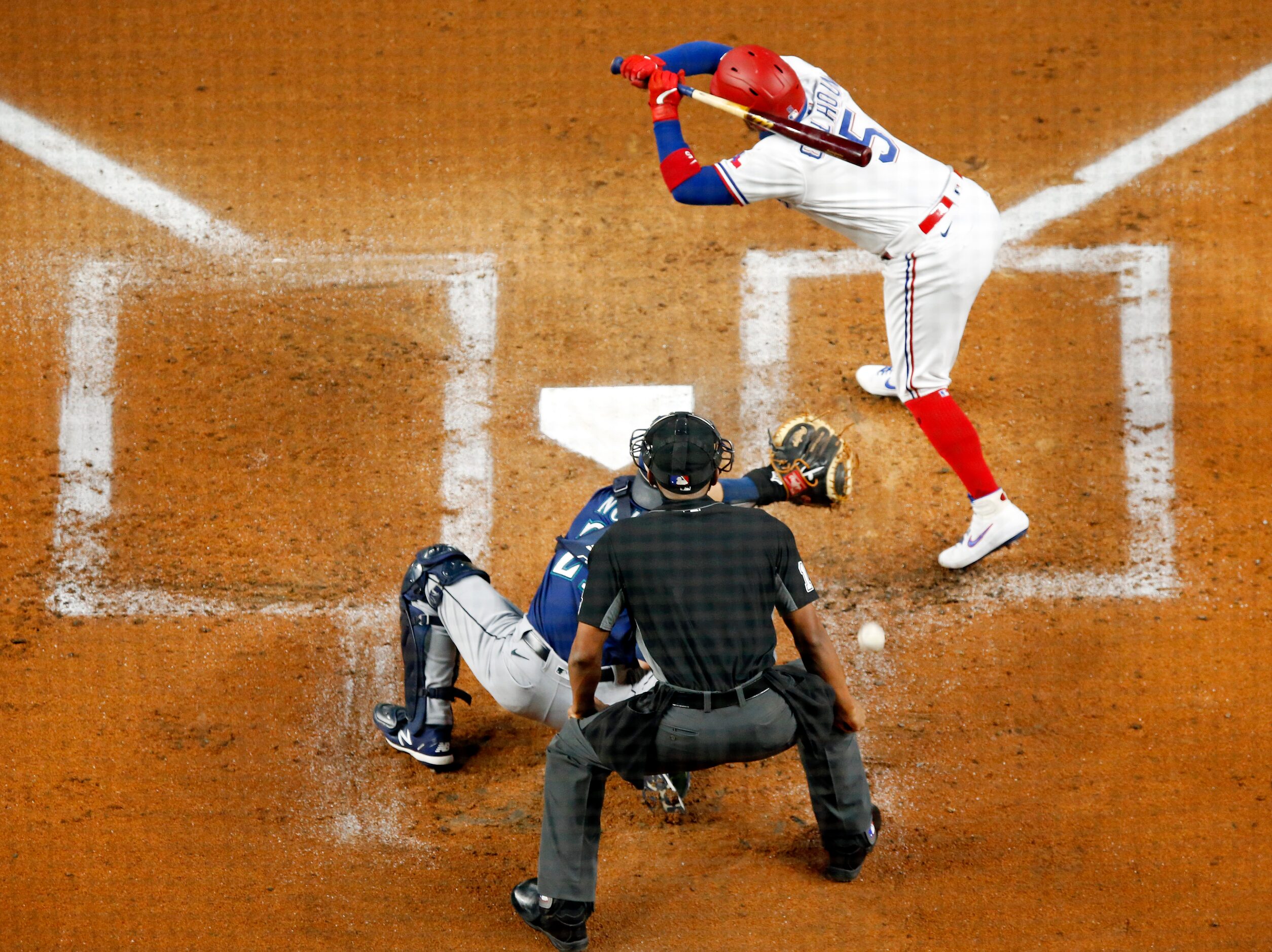 Texas Rangers Willie Calhoun (5) jumps out of the way of a pitch thrown by Seattle Mariners...