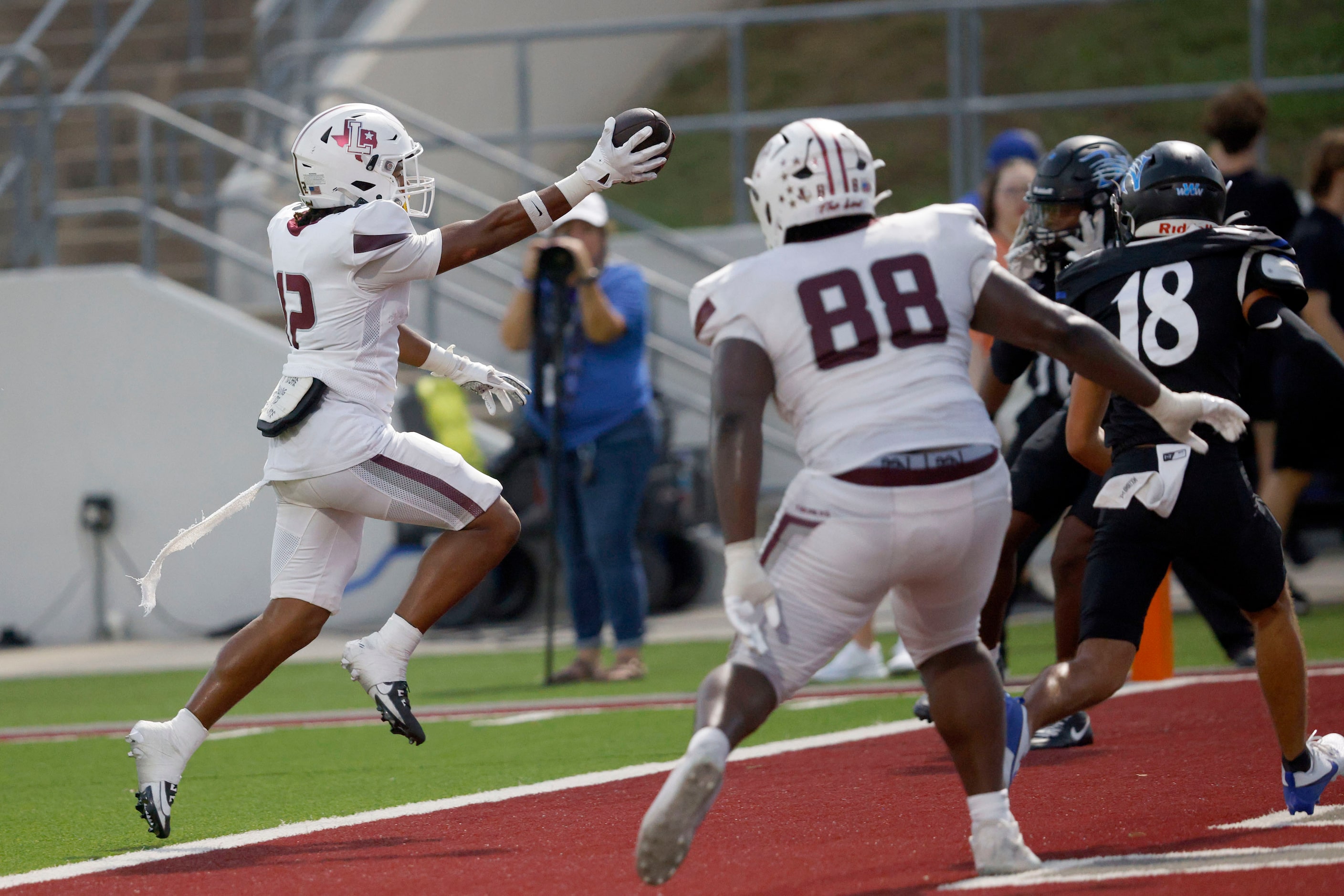 Lewisville's Derrick Martin (12) scores a touchdown over Byron Nelson's Logan Cortez (18)...