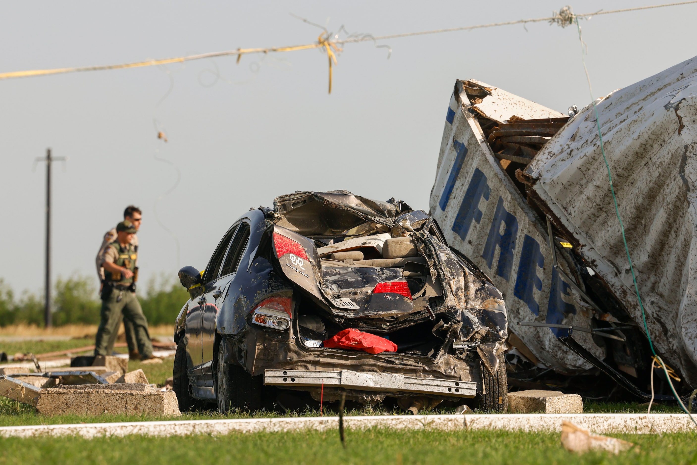 Law enforcement authority members scout a heavily damaged Shell gas station, on Sunday, May...