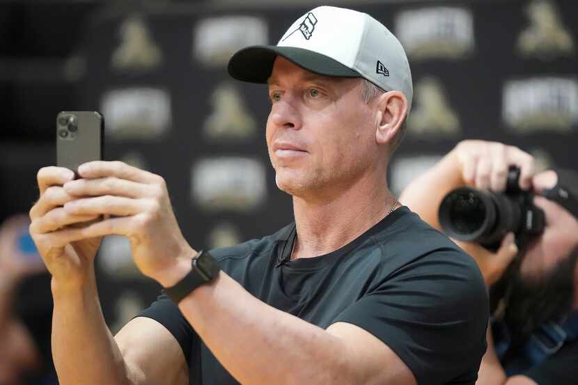 Troy Aikman records a performance by students during a pep rally at Henryetta High School on...