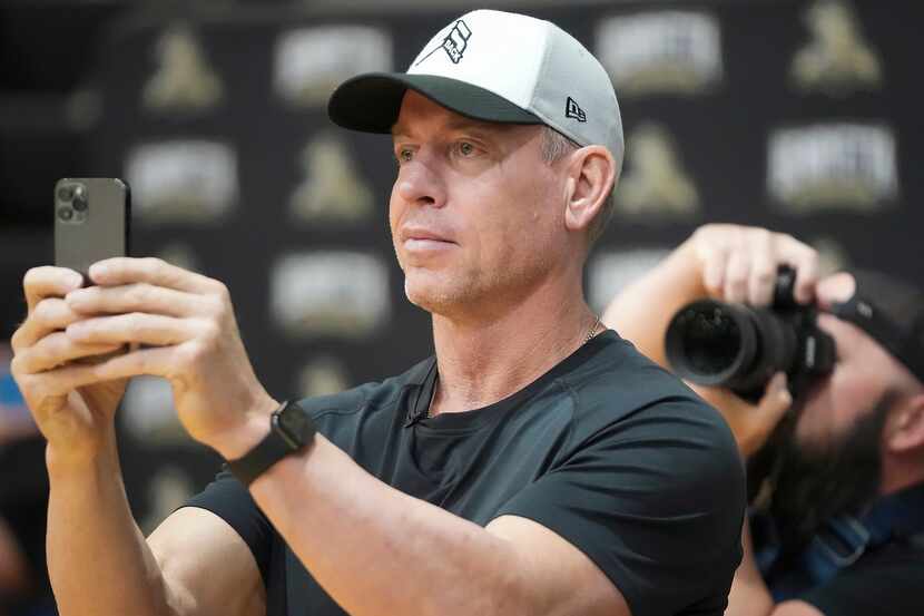 Troy Aikman records a performance by students  during a pep rally at Henryetta High School...