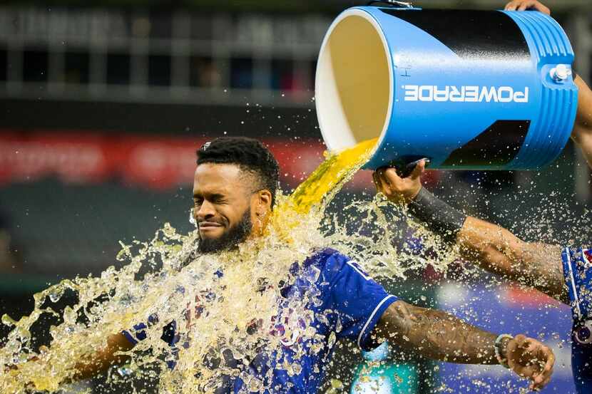 Texas Rangers left fielder Delino DeShields is doused with sports drink after a 14-3 victory...