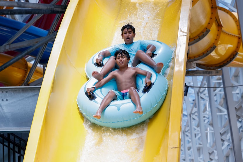 Zayn Raza, 11 (top), and Armaan Rizvi, 11, drop down a water slide at Epic Waters in Grand...