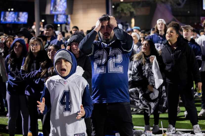 Justin Armendariz and son Maddox Armendariz, 11, watch as the Cowboys fail to catch up to...