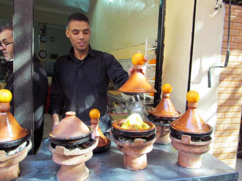This January 2013 photo shows tagines, or meat and vegetables stews, cooking outside the...