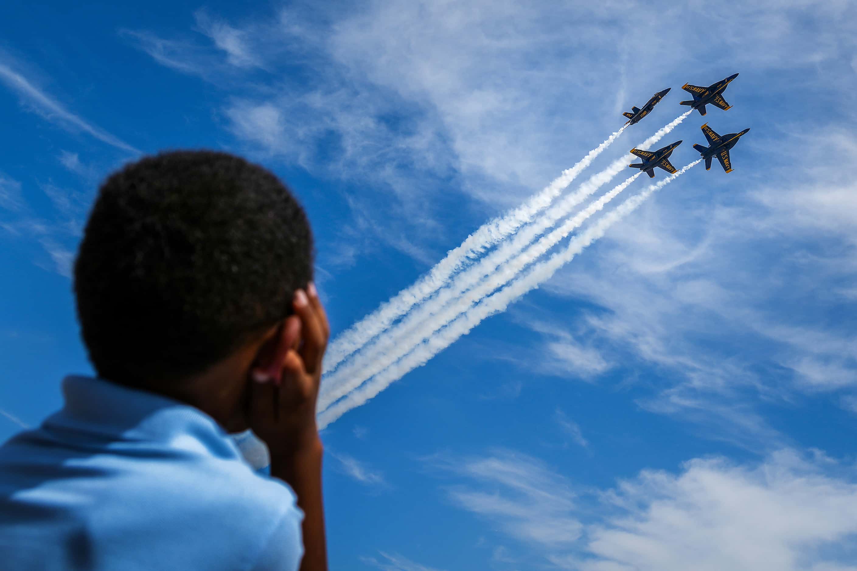 A youngster covers his ears as the Blue Angels perform at the Wings Over Cowtown Airshow on...