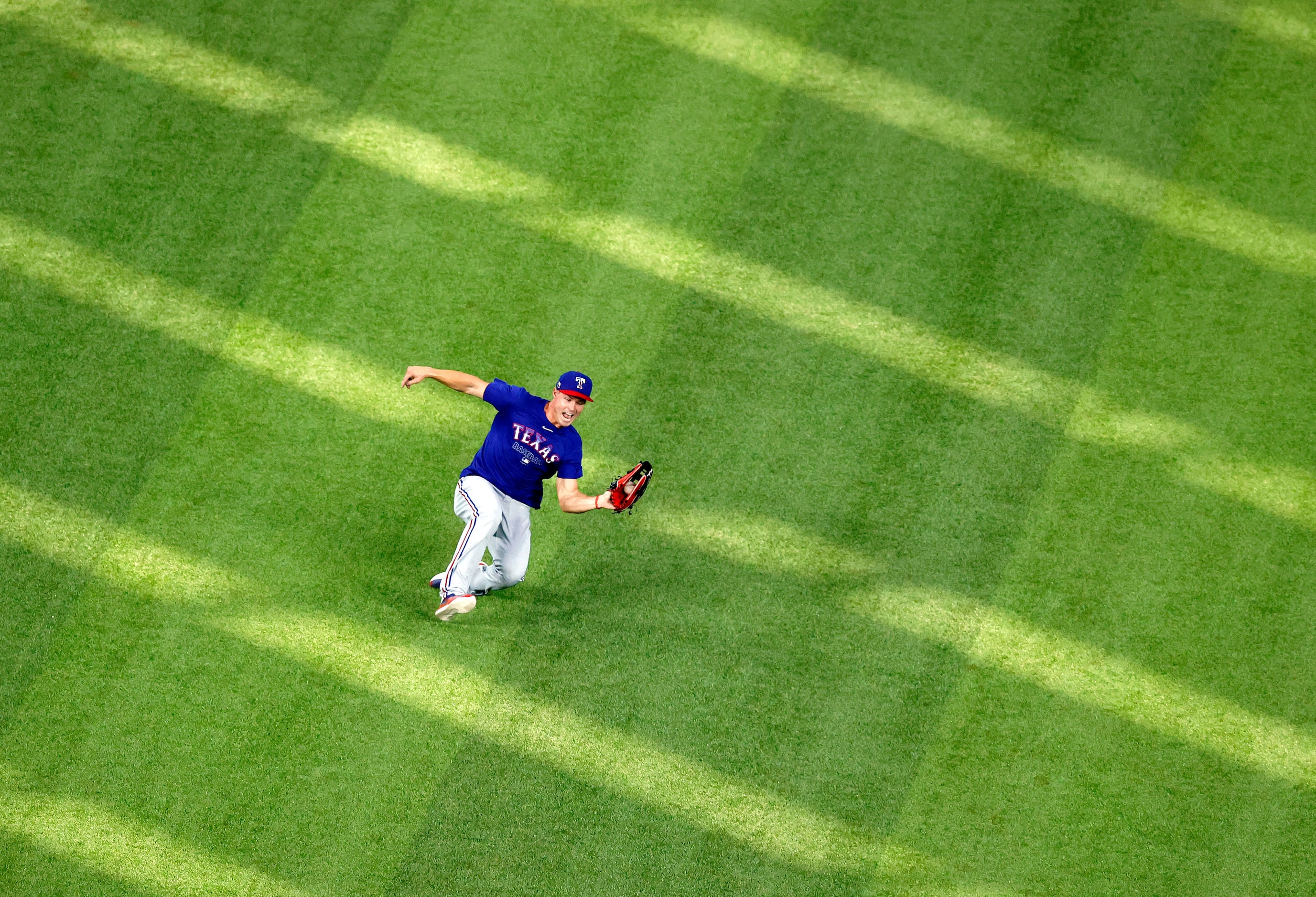 Texas Rangers outfielder Scott Heineman gave chase to a fly ball handmade a sliding catch...